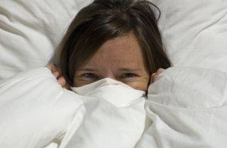 duvet bedding, playful woman peeking out of duvet, goose down duvet, white duvet